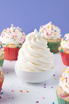 several cupcakes with white frosting and sprinkles