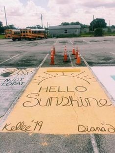 there is a yellow sign that says hello sunshine on the ground next to orange cones