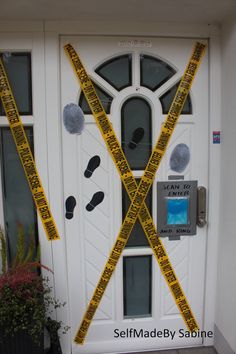 a white door with yellow tape on it and two scissors taped to the front of it