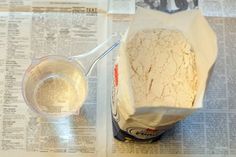 a paper bag filled with ice cream next to a cup of water on top of a newspaper