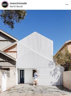 a person walking in front of a white building