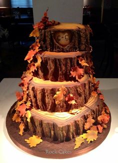 a three tiered cake decorated with fall leaves