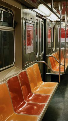 an empty subway car with orange seats