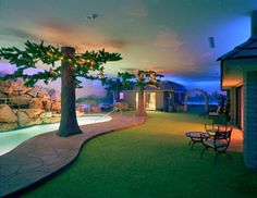 an outdoor swimming pool at night with lights on the trees