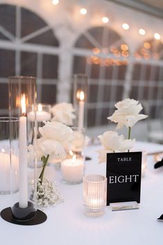 the table is set with candles, flowers and place cards for an elegant wedding reception