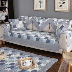 a blue and white checkered couch in a living room with two pictures on the wall