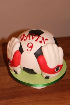 there is a cake that looks like a soccer ball with gloves on it and the number nine