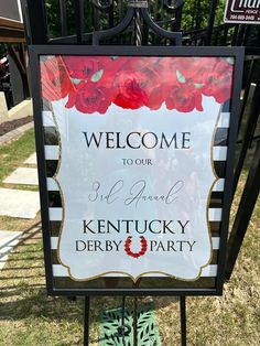 a welcome sign for kentucky derby party in front of a gate with roses on it