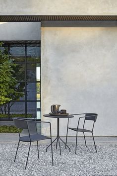 two chairs and a table in front of a building