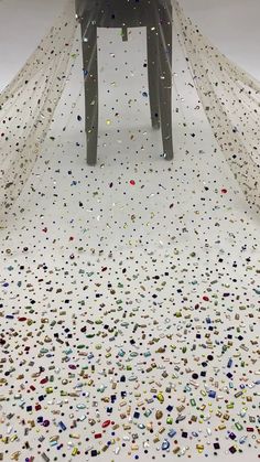 a chair sitting on top of a white floor covered in confetti