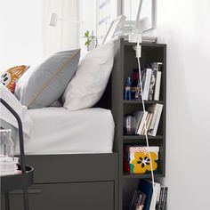 a bed with a book shelf next to it and some books on the bottom shelf