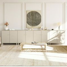 an empty living room with white walls and wooden furniture in front of a large painting on the wall