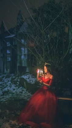 a woman in a red dress holding candles