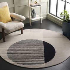 a living room area with a chair, rug and potted plant on the floor