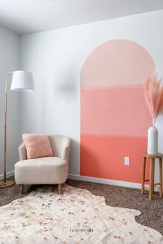 a living room with a chair, lamp and large painting on the wall behind it