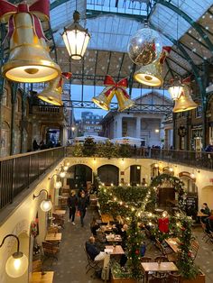 the inside of a building with christmas decorations and lights hanging from it's ceiling