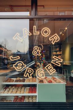 a store window with neon signs and doughnuts