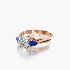 a diamond and blue sapphire ring on a white background