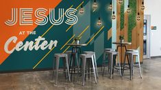 the interior of a church with tables and stools in front of a colorful wall