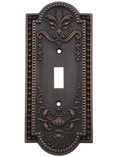 an ornate light switch plate cover with decorative designs on the front and back plates in antique bronze