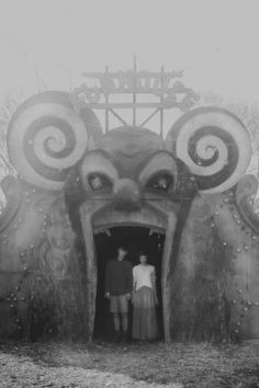 two people are standing in the entrance to a strange looking structure that looks like an octopus