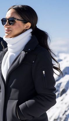 a woman standing on top of a snow covered mountain