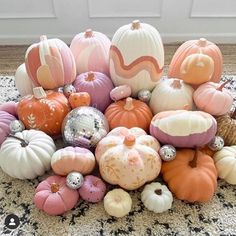 a pile of pumpkins sitting on top of a rug