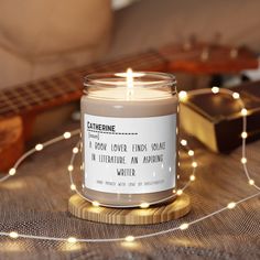 a candle sitting on top of a table next to a string of lights and a guitar