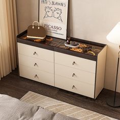 a bedroom with a bed, dresser and lamp on it's side table in front of a window