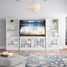 a large flat screen tv mounted to the side of a white entertainment center in a living room