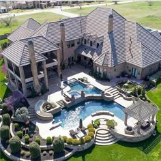 an aerial view of a large house with a pool in the middle and landscaping around it