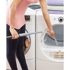 a woman is using a washing machine to wash her clothes