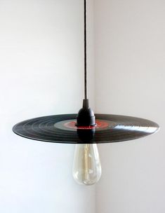 a record hanging from a light fixture in a room with white walls and flooring