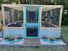 a small garden shed with several plants in it