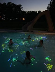 some people are in the water with glow stickers on their backs and arms as they swim