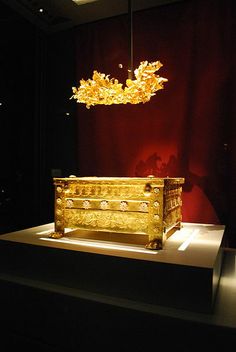 an elaborate gold chest on display in a dark room