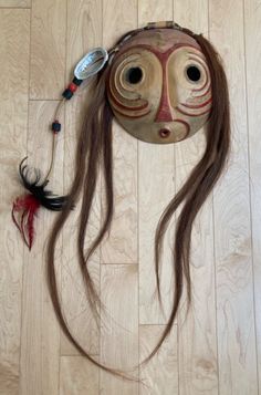 a mask is laying on the floor next to a feather