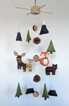 a mobile made out of wood with animals and pine cones hanging from it's sides