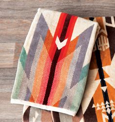 two multicolored rugs sitting on top of a wooden floor next to each other