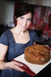 a woman holding a plate with a cake on it