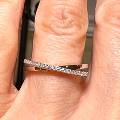 a close up of a person's hand with a diamond ring on their finger