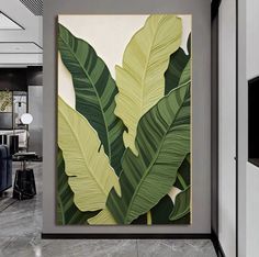 a large green leaf painting on the wall in a living room with grey walls and flooring