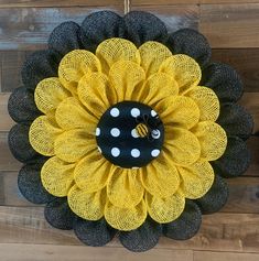 a yellow and black mesh sunflower with a bee on it's center piece