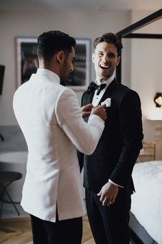 two men in tuxedos are laughing together