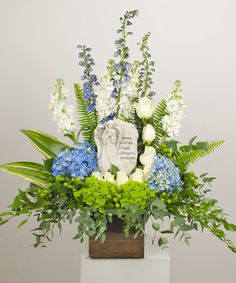 an arrangement of flowers and greenery in a vase