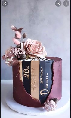 a cake decorated with books and flowers on a plate