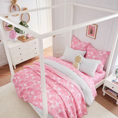 a white bed with pink and white comforters