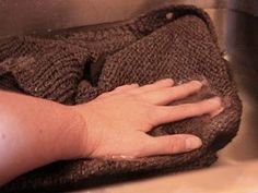 a person is washing their hands in a sink with a towel on top of it