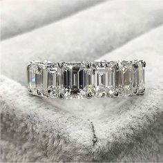 a diamond ring sitting on top of a white blanket