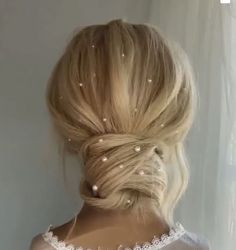 the back of a woman's head with pearls in her hair